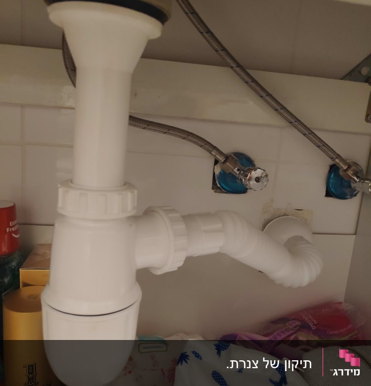 צנרת פלסטיק לבנה מתחת לכיור עם חיבורים